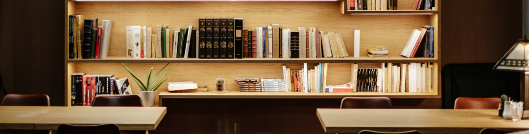 Bookshelf with desks in front of it and pleasant lighting